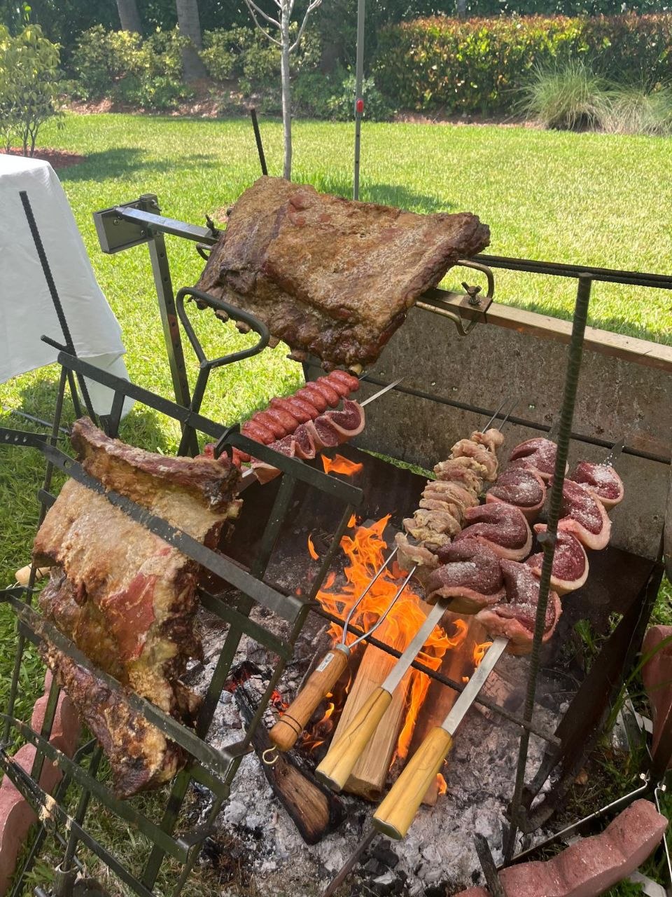 Brazilian BBQ full setup with multiple skewers over open fire
